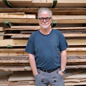 Hauke Schmidt vor einem Stapel Holzbretter